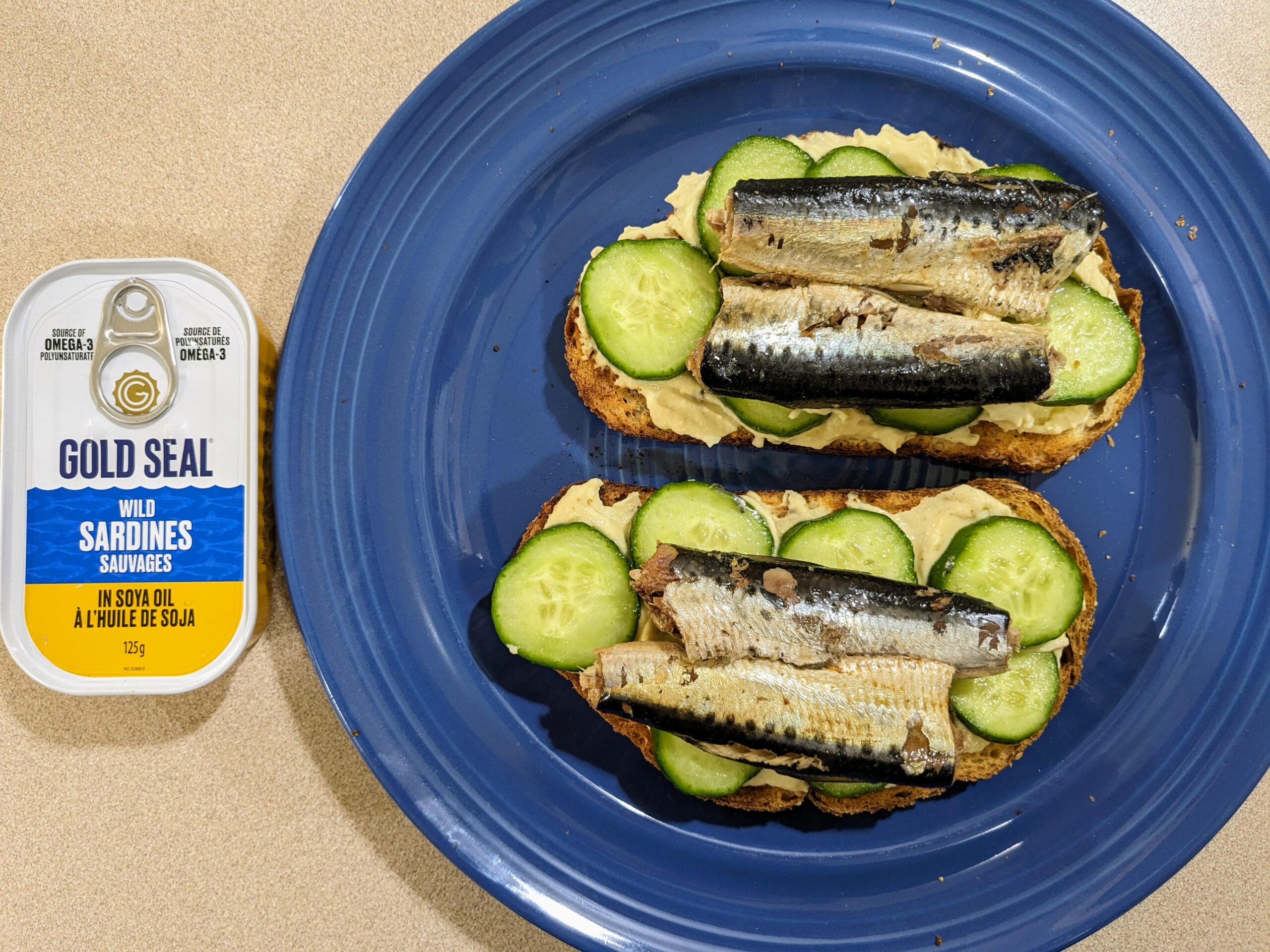 Sardines with hummus and cucumbers (fake kiwis) on toast Dining and