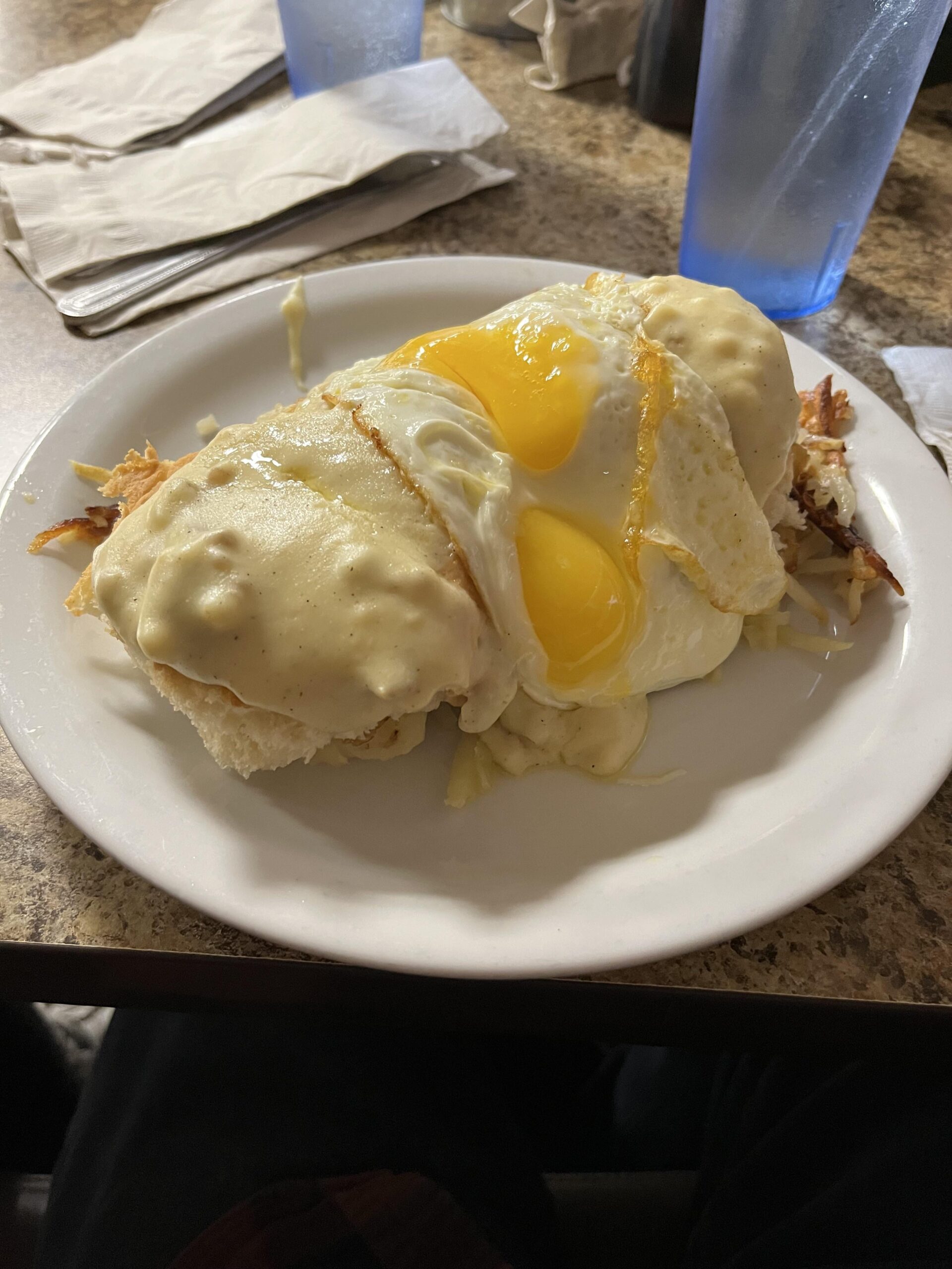 Biscuits and gravy on hash browns with fried eggs on top - Dining and ...